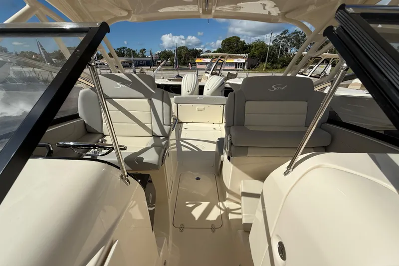 Slide: The Image of 2026 Scout 255 Dorado boat interior with seating and helm, under clear blue sky. - 27