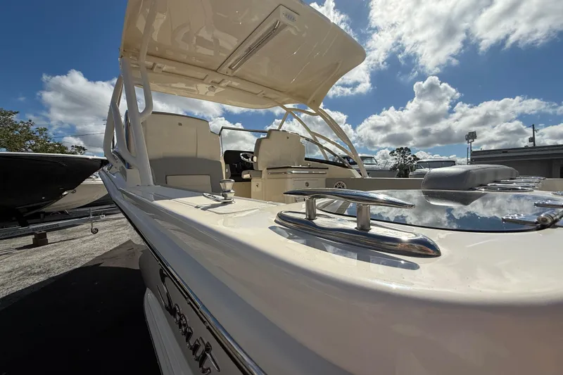 Slide: The Image of 2026 Scout 255 Dorado boat with sleek design under a partly cloudy sky. - 31