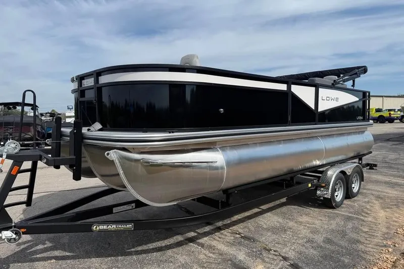 Slide: The Image of 2026 Lowe LF 214 pontoon boat on trailer, parked outdoors. - 1