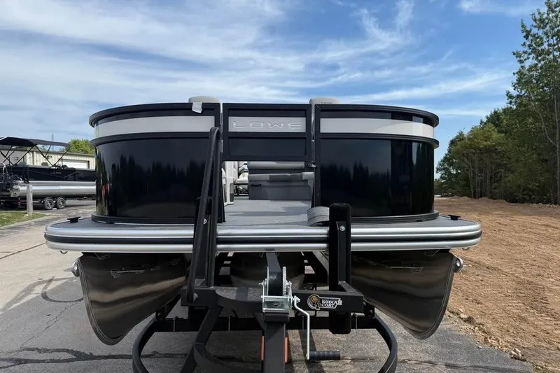 Slide: The Image of 2026 Lowe LF 214 pontoon boat on trailer, parked outdoors under blue sky. - 2