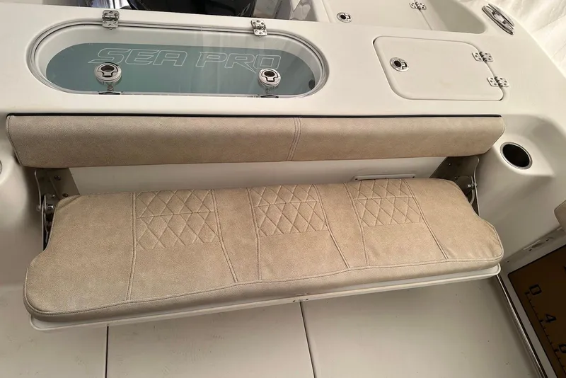 Slide: The Image of 2022 Sea Pro 239 Center Console boat seat with beige upholstery and storage compartment. - 10