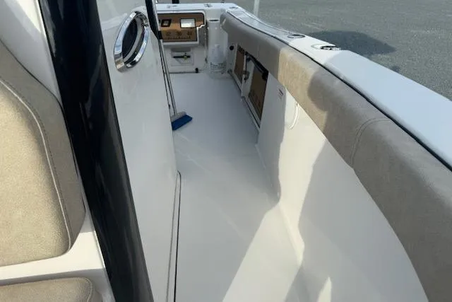 Slide: The Image of 2022 Sea Pro 239 Center Console boat interior with cushioned seating and control panel. - 14