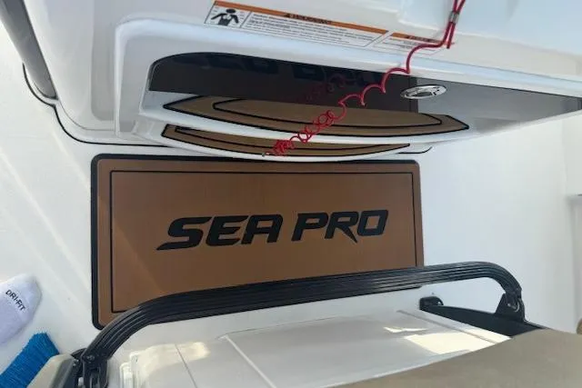 Slide: The Image of 2022 Sea Pro 239 Center Console boat interior with branded mat and storage compartment. - 15