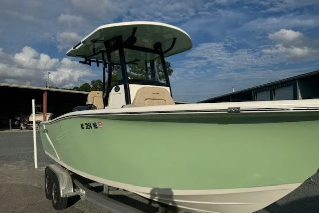 Slide: The Image of 2022 Sea Pro 239 Center Console boat on trailer, light green hull, parked outdoors. - 2