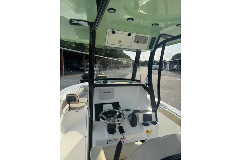 Slide: The Image of 2022 Sea Pro 239 Center Console boat interior with steering wheel and navigation equipment. - 6