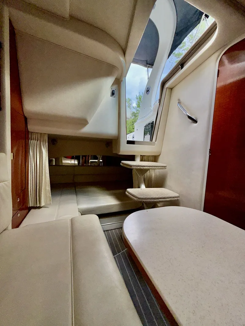 Slide: The Image of Interior of 2004 Sea Ray 300 Sundancer boat, featuring seating and table area. - 12