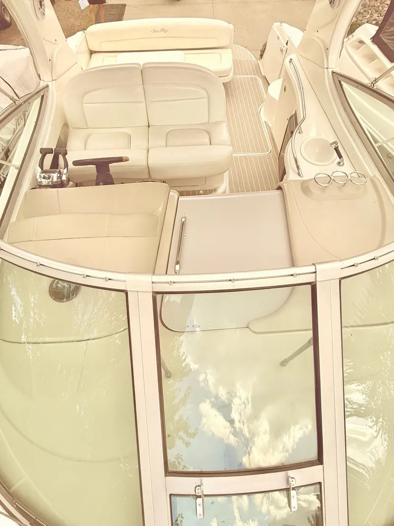 Slide: The Image of 2004 Sea Ray 300 Sundancer boat interior with beige seating and glass panels. - 3
