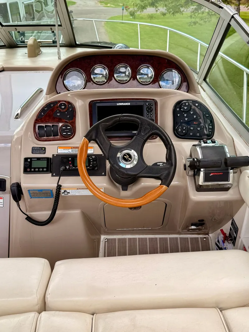 Slide: The Image of 2004 Sea Ray 300 Sundancer helm with steering wheel, gauges, and navigation controls. - 8