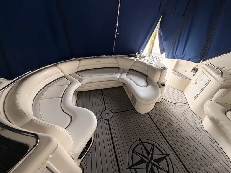 Slide: The Image of 2006 Cruisers Yachts 560 Express interior with curved seating and nautical-themed flooring. - 10