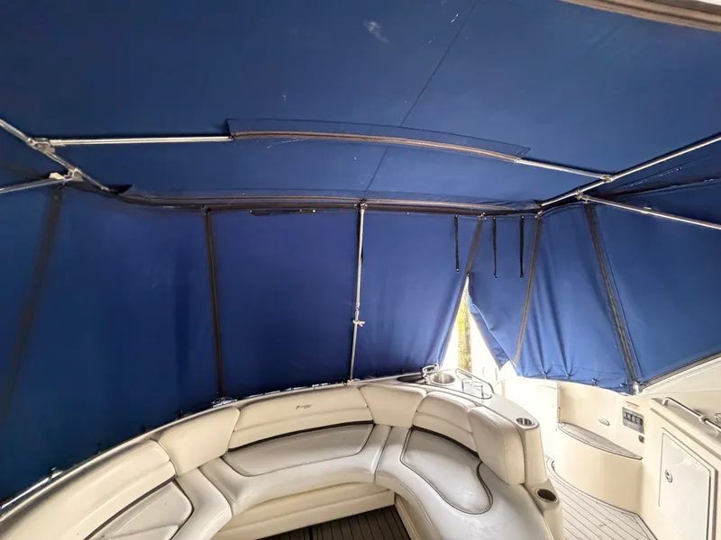 Slide: The Image of 2006 Cruisers Yachts 560 Express interior with blue canopy and curved seating. - 11