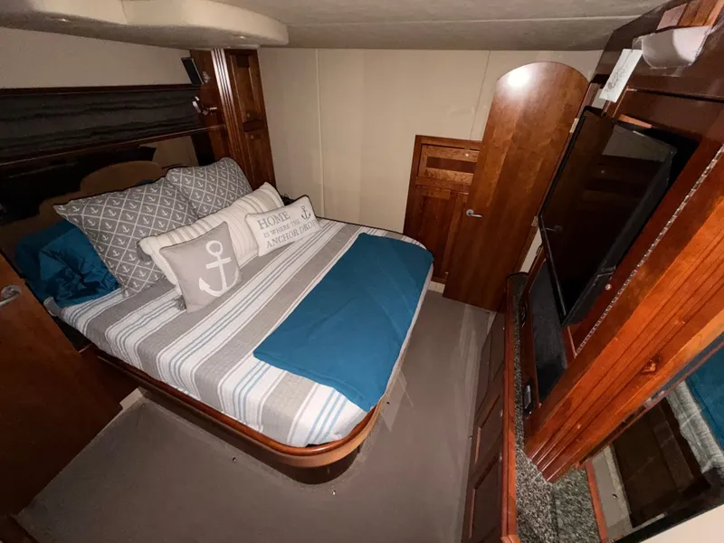 Slide: The Image of Luxurious cabin interior of 2006 Cruisers Yachts 560 Express with cozy bedding and wooden accents. - 12