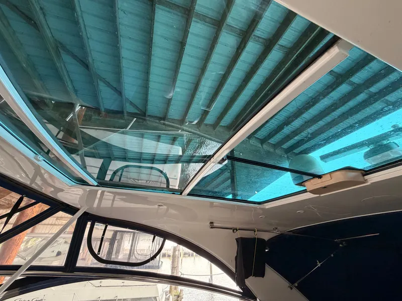 Slide: The Image of Glass roof of a 2006 Cruisers Yachts 560 Express under a covered dock. - 18