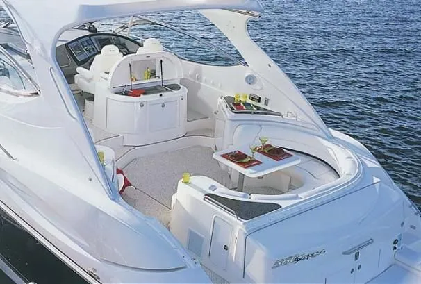 Slide: The Image of 2006 Cruisers Yachts 560 Express, luxury yacht interior with seating and dining area on water. - 24
