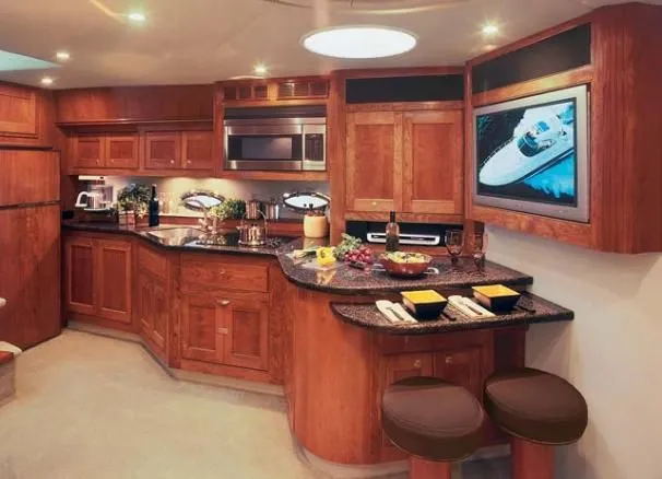Slide: The Image of Luxurious 2006 Cruisers Yachts 560 Express kitchen with wood cabinetry and modern amenities. - 26
