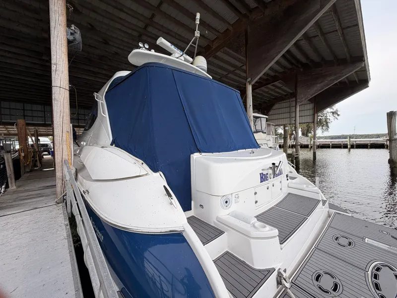 Slide: The Image of 2006 Cruisers Yachts 560 Express docked under a covered marina. - 4