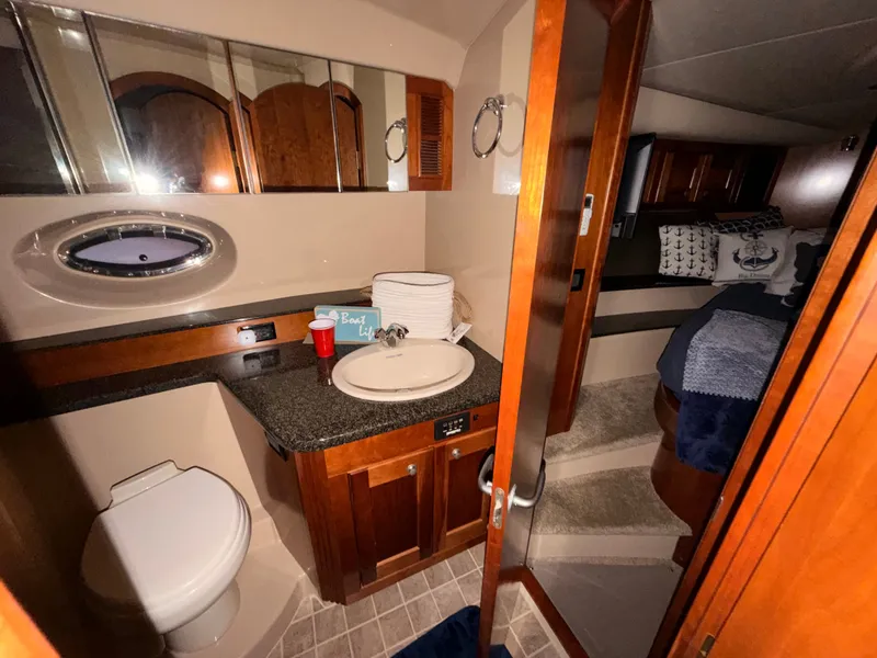 Slide: The Image of Luxurious 2006 Cruisers Yachts 560 Express bathroom and bedroom interior with elegant wood finishes. - 16