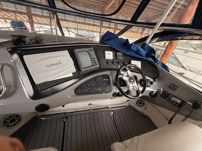 Slide: The Image of 2006 Cruisers Yachts 560 Express helm with Garmin navigation system and steering wheel. - 19