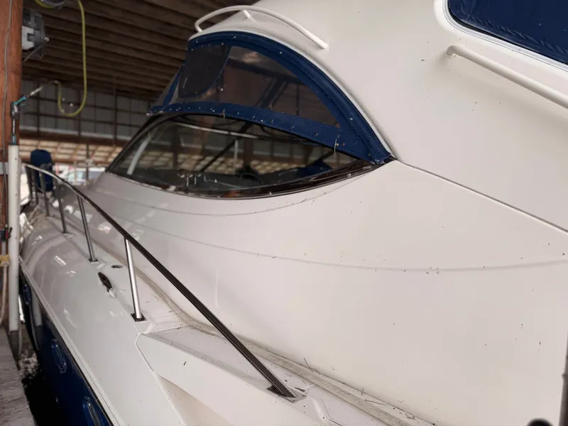 Slide: The Image of 2006 Cruisers Yachts 560 Express in a covered dock, showcasing sleek design and windows. - 7