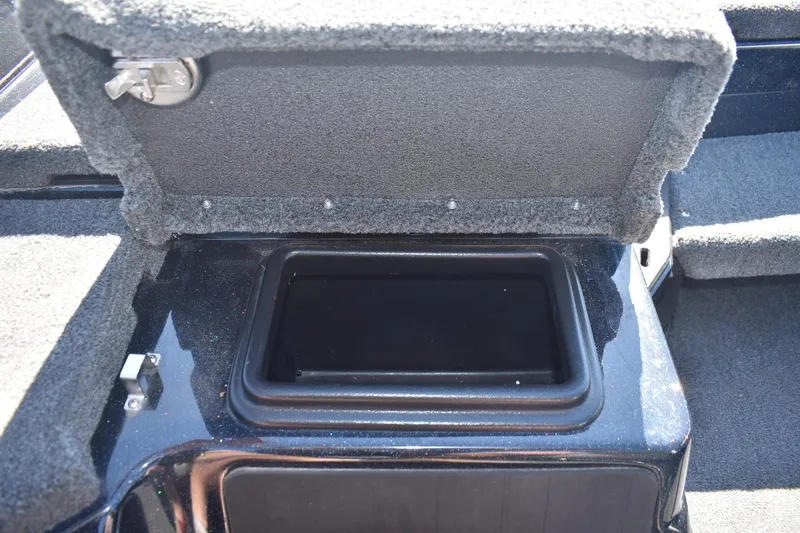 Slide: The Image of Open storage compartment in 2023 Skeeter ZXR20 boat, featuring carpeted interior and secure latch. - 13