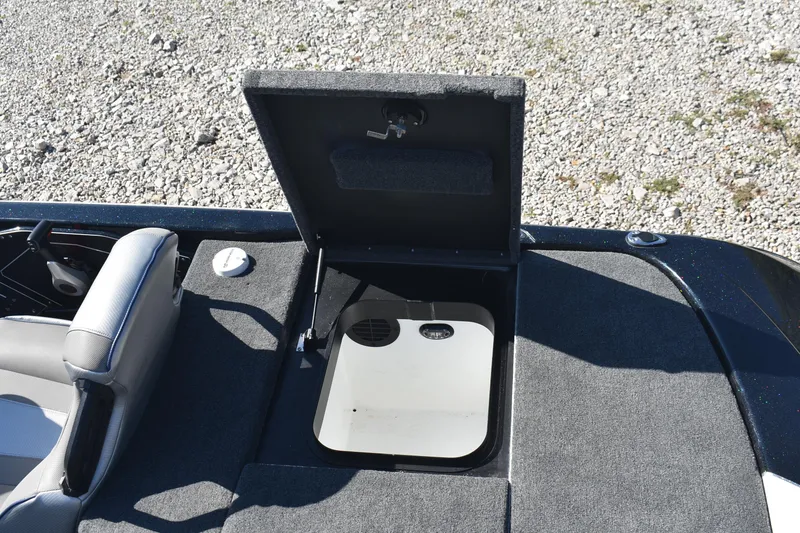 Slide: The Image of 2023 Skeeter ZXR20 boat storage compartment open on gravel surface. - 16