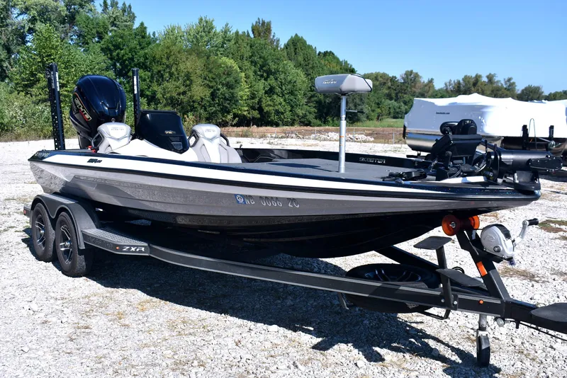 Slide: The Image of 2023 Skeeter ZXR20 boat on trailer, parked outdoors, surrounded by trees. - 4