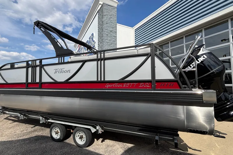 Slide: The Image of 2026 JC Sporttoon 26TT pontoon boat on trailer, displayed outdoors near a building. - 3