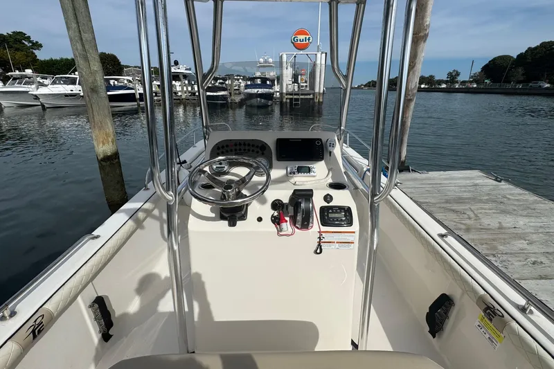 Slide: The Image of 2021 Carolina Skiff 21 LS boat at dock, featuring steering console and controls. - 10