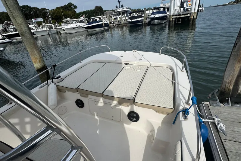 Slide: The Image of 2021 Carolina Skiff 21 LS boat docked at marina with cushioned seating. - 16