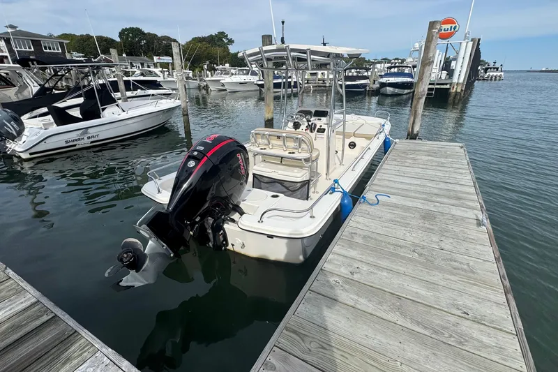 Slide: The Image of 2021 Carolina Skiff 21 LS boat docked at marina with outboard motor. - 3