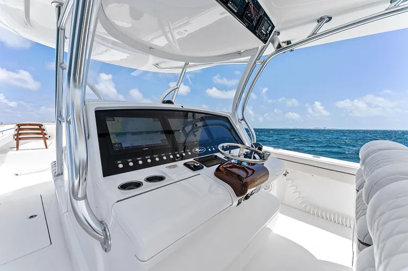 Slide: The Image of 2021 Valhalla Boatworks V-41 helm with modern controls, navigating clear blue ocean waters. - 42