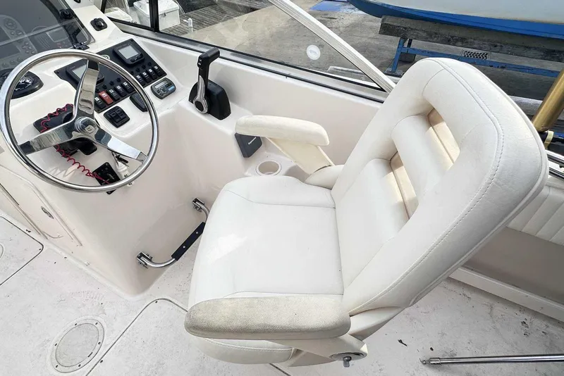 Slide: The Image of 2007 Grady-White Tournament 225 boat cockpit with steering wheel and white captain's chair. - 19