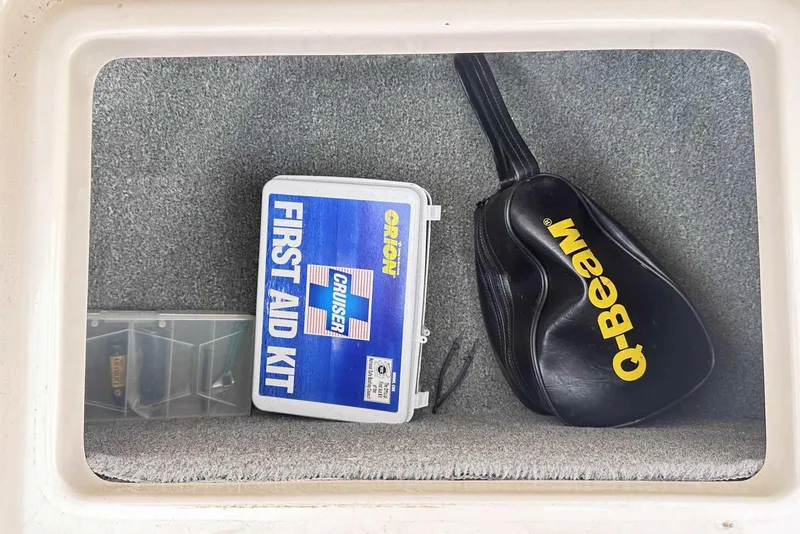 Slide: The Image of Storage compartment in a 2007 Grady-White Tournament 225 with first aid kit and Q-Beam bag. - 31