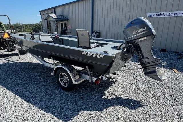 Slide: The Image of 2025 Alweld 1856 PF boat with Yamaha motor on a trailer, parked on gravel. - 4