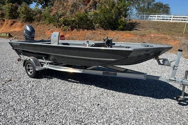 Slide: The Image of 2025 Alweld 1856 PF boat on trailer, parked on gravel, with trees in background. - 6
