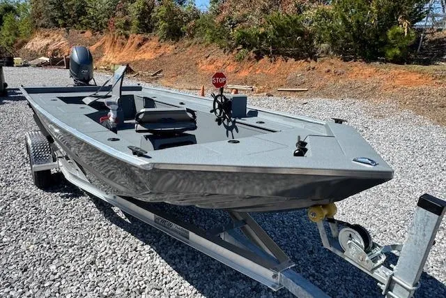 Slide: The Image of 2025 Alweld 1856 PF boat on trailer, parked on gravel, surrounded by trees. - 7