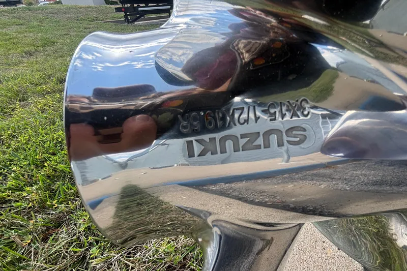 Slide: The Image of Close-up of a shiny Suzuki boat propeller with engraved specifications. - 45