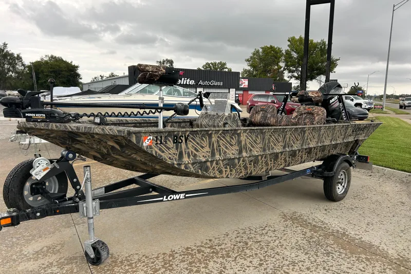 Slide: The Image of 2016 Lowe Roughneck 1756SC camo boat on trailer, parked outdoors. - 4