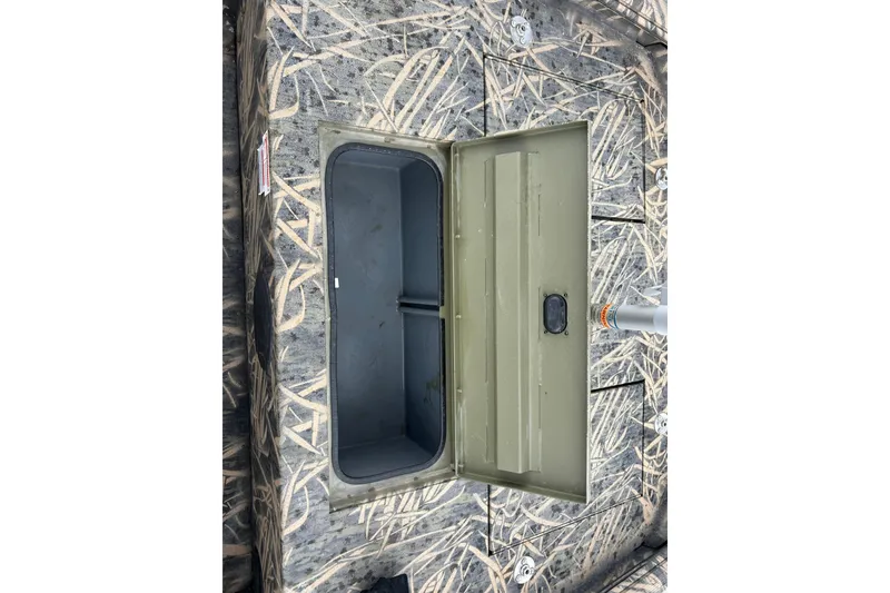 Slide: The Image of Open storage compartment on 2016 Lowe Roughneck 1756SC boat with camouflage pattern. - 9
