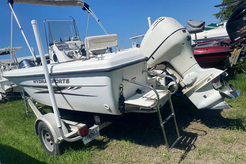 The Image of 2003 Hydra-Sports 180 CC boat on trailer with outboard motor, parked on grass. - 0