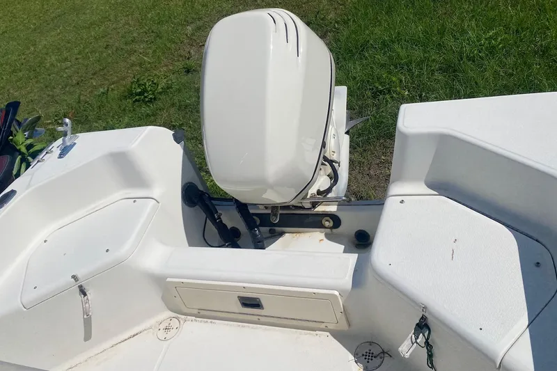 Slide: The Image of 2003 Hydra-Sports 180 CC boat with outboard motor, white interior, and grassy background. - 10