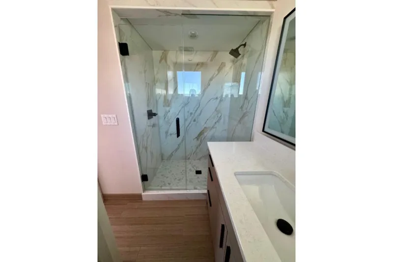 Slide: The Image of Modern bathroom with glass shower, marble walls, and sleek vanity in Adonia Aspire Trip #7, 2024. - 14