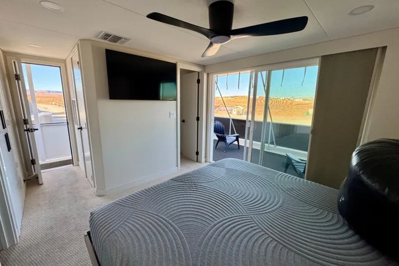 Slide: The Image of Modern bedroom in 2024 Adonia Aspire Trip #7 RV, featuring a ceiling fan and outdoor view. - 19