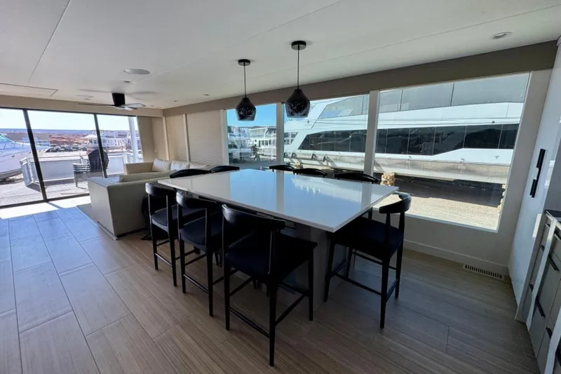 Slide: The Image of Modern yacht interior with dining area, large windows, and sleek design, Adonia Aspire Trip #7, 2024. - 5