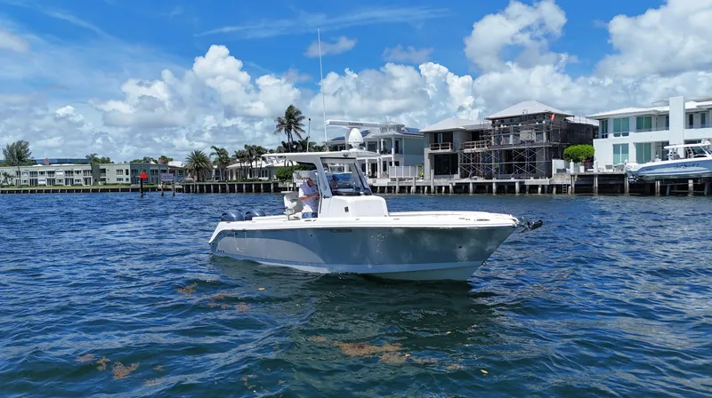 Slide: The Image of 2017 Edgewater 262CC boat on water near luxury waterfront homes. - 1