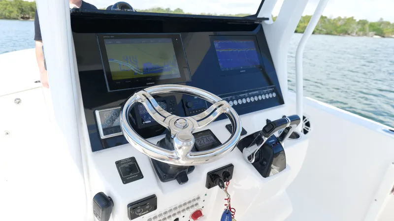 Slide: The Image of 2017 Edgewater 262CC boat console with steering wheel and navigation screens. - 10
