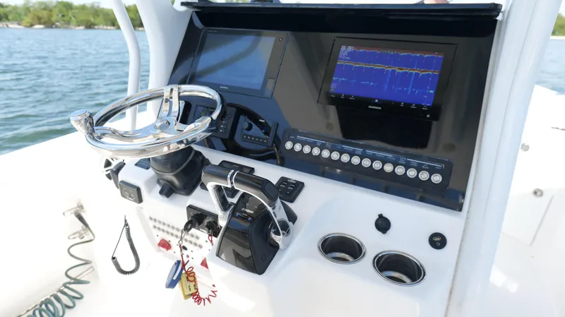 Slide: The Image of 2017 Edgewater 262CC boat dashboard with steering wheel and navigation screens. - 11