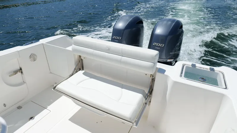 Slide: The Image of 2017 Edgewater 262CC boat with dual engines and white seating on open water. - 24