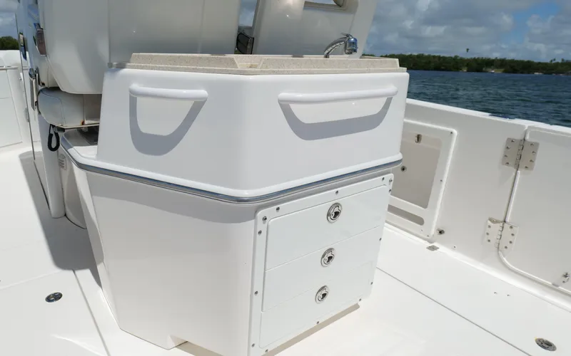 Slide: The Image of Edgewater 262CC 2017 boat interior with storage drawers and sink, on a sunny day. - 27