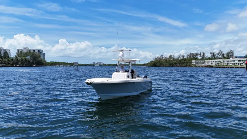 Slide: The Image of 2017 Edgewater 262CC boat on calm water under a clear blue sky. - 3