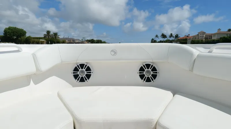 Slide: The Image of 2017 Edgewater 262CC boat interior with white seating and speakers under a blue sky. - 42